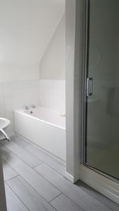 a bathroom with a bath tub and a shower at Grovehouse in Portstewart +20 photos
