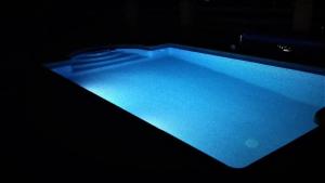 una piscina azul de agua en una habitación oscura en Casa Liebre en Alozaina