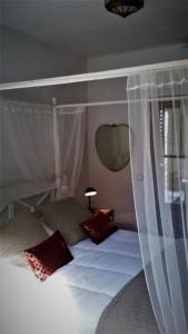 1 dormitorio con cama con dosel y almohadas rojas en Casa Liebre en Alozaina