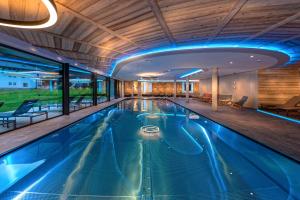 a swimming pool in a hotel with blue lighting at Alpinhotel Berghaus spa in Tux