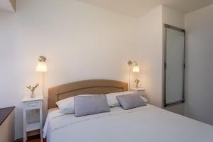 a bedroom with a large white bed with two pillows at Beautiful Apartment Jelena 1 in Veli Lošinj