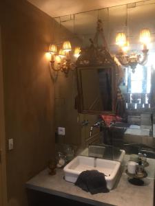 a bathroom with a sink and a mirror at La Maison Rousseau Chambre d'hôtes in Nîmes