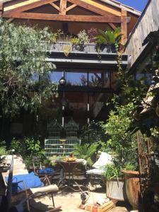 a patio with a table and chairs in a garden at La Maison Rousseau Chambre d'hôtes in Nîmes