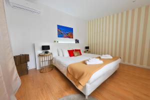ein Schlafzimmer mit einem großen weißen Bett mit roten Kissen in der Unterkunft Private House Only For You 133 - 8min historicCenter in Vila Nova de Gaia