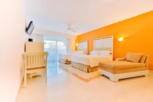 une chambre d'hôtel avec deux lits et une chaise dans l'établissement Occidental Costa Cancún - All Inclusive, à Cancún