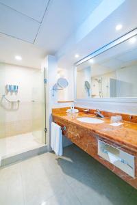a bathroom with a large sink and a shower at Occidental Costa Cancún - All Inclusive in Cancún