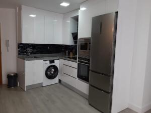 a kitchen with a refrigerator and a washing machine at Nuevo junto a Catedral in Murcia
