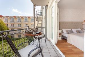 Zimmer mit einem Balkon, einem Bett und einem Tisch in der Unterkunft Appartement - Kleine Auszeit in Binz