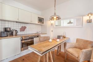 eine Küche mit einem Holztisch und 2 Stühlen in der Unterkunft Appartement - Kleine Auszeit in Binz