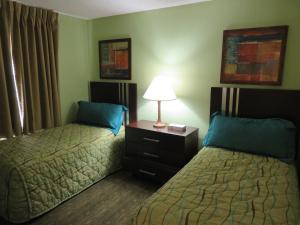 a hotel room with two beds and a lamp at Surfsider Resort - A Timeshare Resort in Pompano Beach