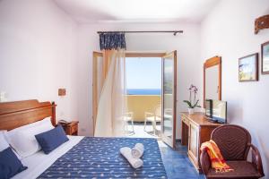 a bedroom with a bed and a balcony with the ocean at Hotel Village Suvaki in Pantelleria