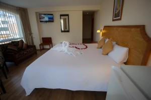 a bedroom with a large white bed with a ribbon on it at Sol Plaza Hotel in Puno