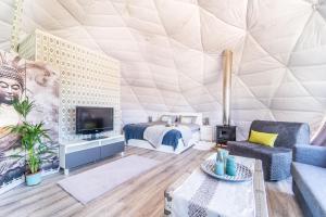 a living room with a bed and a tv in a tent at Luxury Dome Retreat in Dúdar