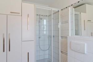 a white bathroom with a shower and a sink at Traumblick Ferienwohnung in Sauzin
