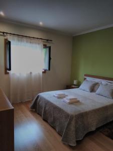 a bedroom with a large bed and a window at BellaVista Alojamento in Arouca
