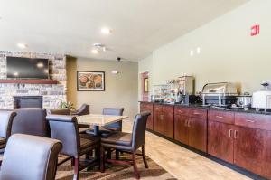 a restaurant with a table and chairs and a counter at Cobblestone Inn & Suites - Ord in Ord