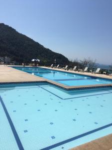 uma grande piscina com água azul e cadeiras em Porto Real The View em Mangaratiba