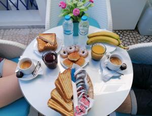 a white table with breakfast foods and drinks on it at Samson΄s Village in Perissa