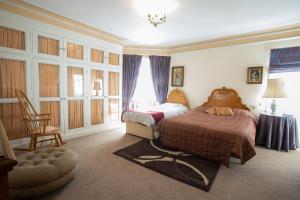 una camera con due letti e una sedia di Fines Bayliwick Hotel a Bracknell Altre 37 foto