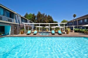 a swimming pool with a pool table and chairs at Maple Tree Inn in Sunnyvale