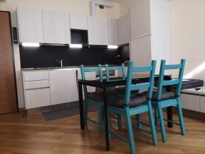 - une table à manger avec des chaises bleues dans la cuisine dans l'établissement PATAVIUM APARTMENT, à Padoue