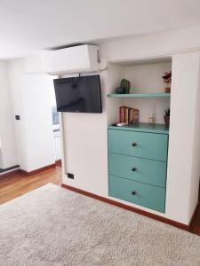um quarto com uma cómoda e uma televisão num quarto em Casa Daniele em Gênova