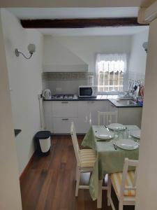 uma cozinha com mesa e cadeiras e uma cozinha com mesa e espreguiçadeira em Casa Daniele em Gênova