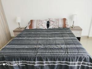 uma cama com um cobertor e almofadas preto e branco em Atlantis Towers Apartamento em Santa Cruz de la Sierra