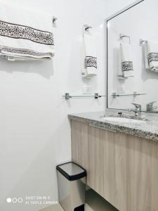 uma casa de banho com lavatório, espelho e toalhas em Atlantis Towers Apartamento em Santa Cruz de la Sierra