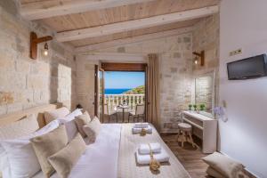 a hotel room with a bed and a view of the ocean at Castro Villas Crete in Palaiokastro