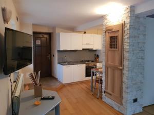una cocina con armarios blancos y una mesa en una habitación en Zimmer Arianna, en Alpe Strencia