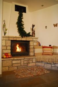 a living room with a fireplace with a christmas tree at Guesthouse Petrino in Pezoúla