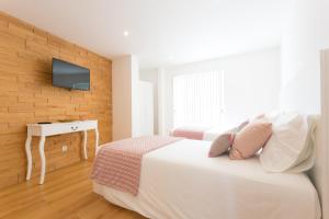 1 dormitorio con 1 cama y TV en la pared en 35th Atlantic View, en Lajes do Pico