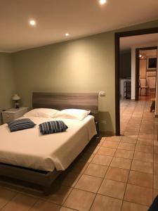 1 dormitorio con 1 cama grande y suelo de baldosa en Relais Le Folaghe, en Ladispoli