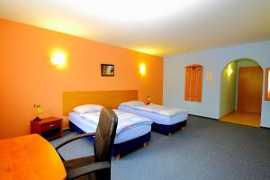 una habitación de hotel con 2 camas y una silla en Restaurant & Hostel "Broadway" en Kliniska