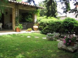 une cour avec des plantes en pot et une maison dans l'établissement Villa Le Casaline, à Messenano