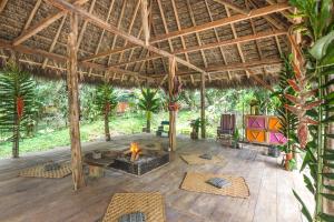 un patio al aire libre con una hoguera en un pabellón en Selina Amazon Tena en Tena