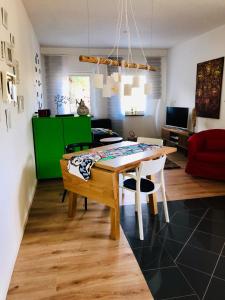 a dining room with a table and a living room at Ferienwohnung Piesbach in Nalbach