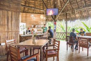 a group of people sitting around a table in a restaurant at Selina Amazon Tena in Tena