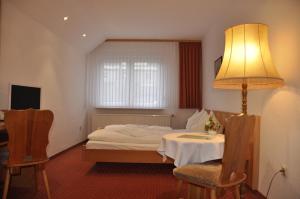 Habitación de hotel con cama y mesa con lámpara en Hotel Berggarten, en Brotterode