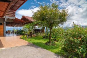 una imagen de una casa con un árbol en el patio en Ladera Hotel, en Turrialba