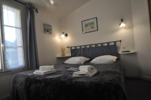 a bedroom with a bed with towels on it at Le Concept Hotel in Les Portes