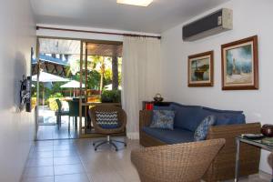 a living room with a couch and chairs and a table at Nannai Residence Muro Alto in Porto De Galinhas