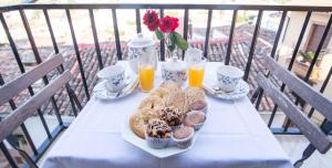 a table with a plate of pastries and two glasses of orange juice at Hostal Alba Taruta in Guadalupe