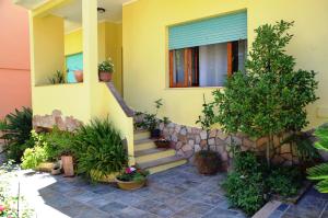 a house with potted plants in front of it at B&b Aloysia in Iglesias