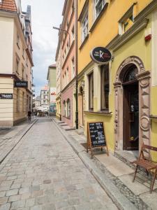 una strada vuota con edifici gialli e rosa di Best Apartments Więzienna Monkeys a Breslavia