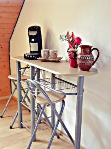 einen Tisch mit Kaffeemaschine und Blumen darauf in der Unterkunft VOLL ausgestattete DG- Wohnung in HDH ruhige zentrale Lage in Heidenheim