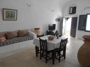 uma sala de estar com uma mesa e um sofá em Rimida Villas em Oia