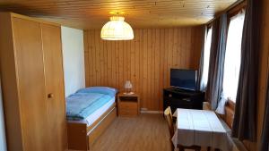 a small bedroom with a bed and a television at Gasthof Rössli Gondiswil in Gondiswil
