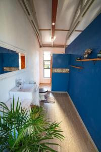baño con lavabo blanco y pared azul en Casa Narinho, en Praia do Tofo